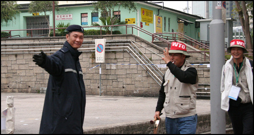 홍콩 경찰이 웃으며 한국 농민에게 길을 안내하고 있다. 